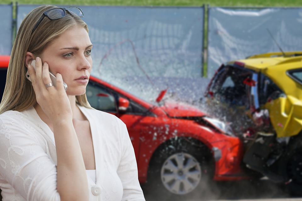 Kvinde ringer foran sammenkørte biler